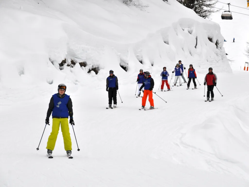 Skifahrende verteilt auf dem Hang unter dem Lift.